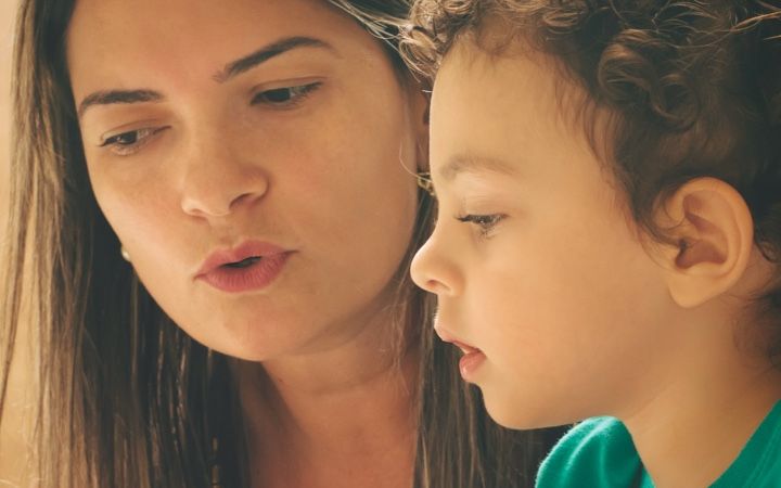 mother talks to young child as they are looking at something together